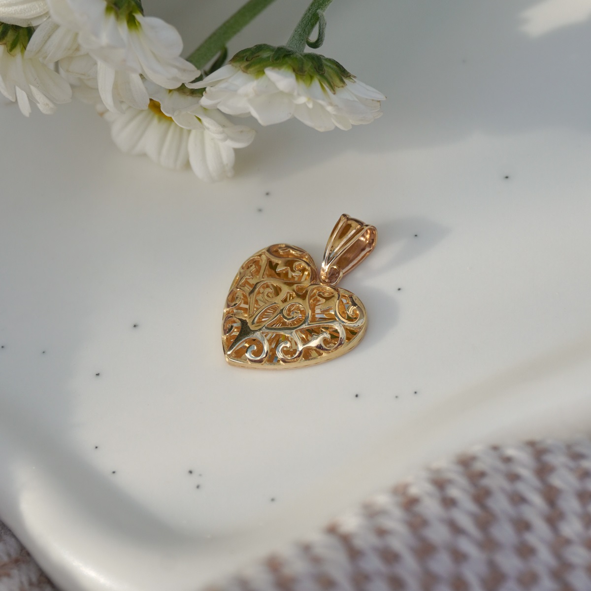 Złota zawieszka w kształcie serca z dekoracyjnym ażurowym wzorem