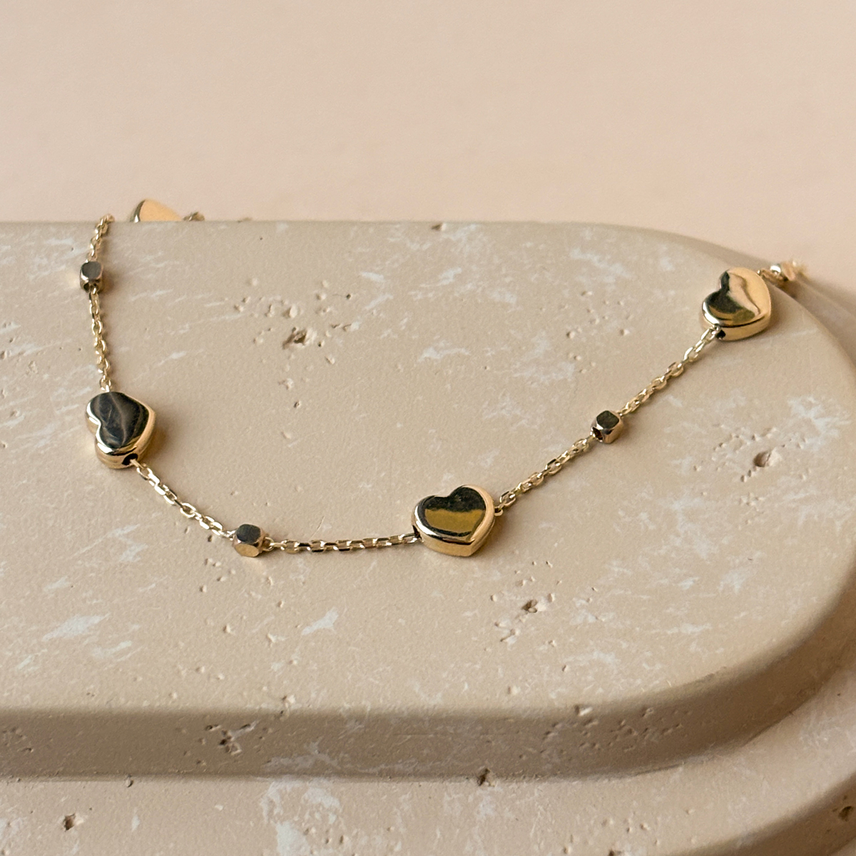 Delikatna złota bransoletka ozdobiona serduszkami