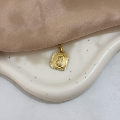 Medalik złoty przedstawiający Matkę Boską.