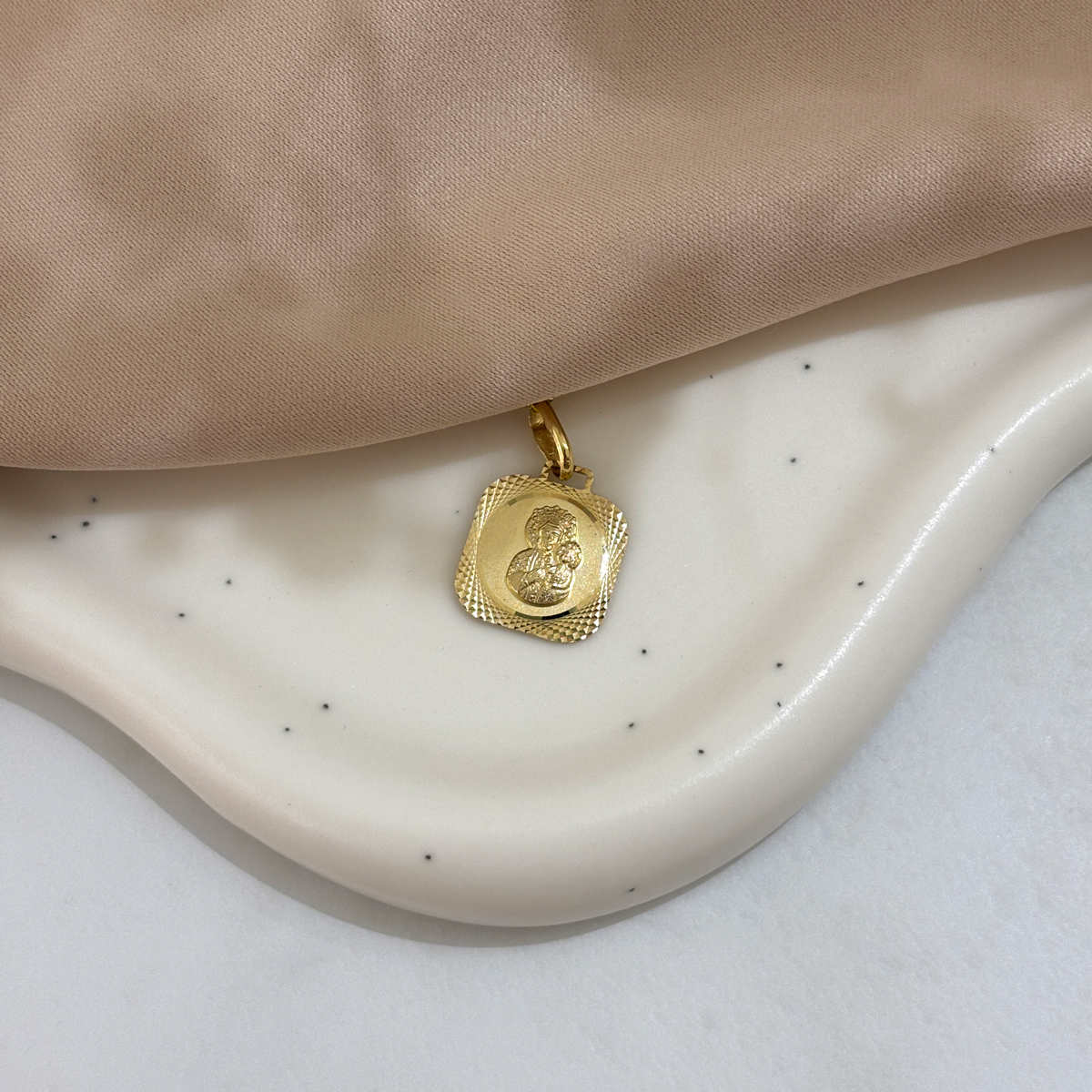 Medalik złoty przedstawiający Matkę Boską.